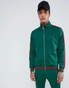 CRIMINAL DAMAGE TRACK JACKET IN GREEN WITH RED SIDE STRIPE - GREEN,CARNABY TRACK TOP