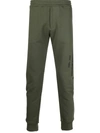 Alexander Mcqueen Logo Print Tapered Track Trousers In Grün