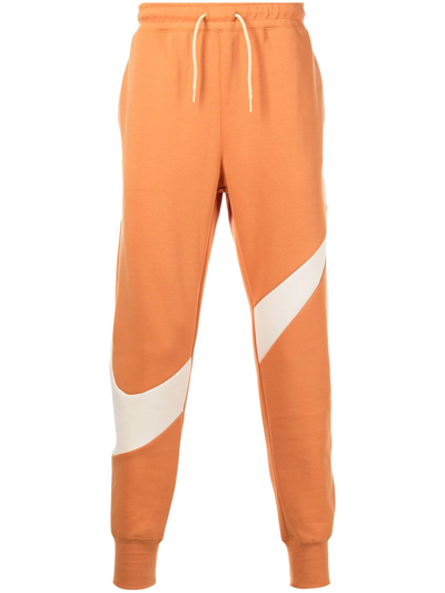 Nike Swoosh-print Fleece Track Pants In Orange