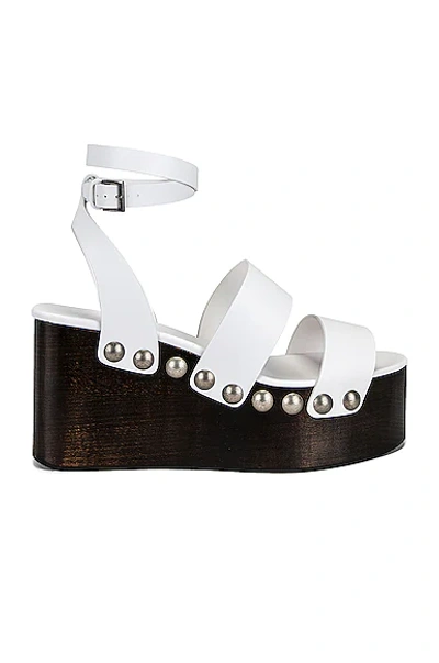 Alaïa 85mm Wooden-heel Wedge Sandals With Shiny Leather Straps And Studs In Blanc Casse