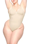 Skims Seamless Sculpt Low Back Thong Bodysuit In Sand