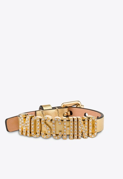 Moschino Crystal Embellished Logo Metallic Leather Bracelet In Gold