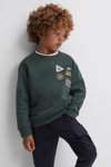 REISS LUCAS - FOREST GREEN JUNIOR RELAXED FIT PATCH CREW NECK JUMPER, AGE 8-9 YEARS