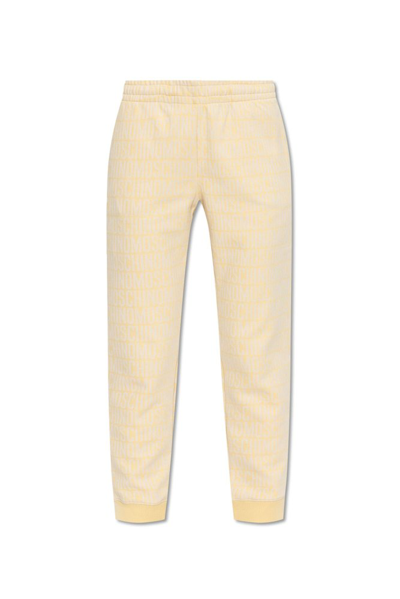 Moschino All Over Monogram Printed Joggers In Yellow