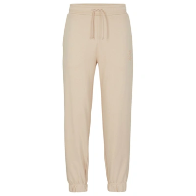 Hugo Relaxed-fit Cotton-terry Tracksuit Bottoms With Stacked Logo In Light Beige