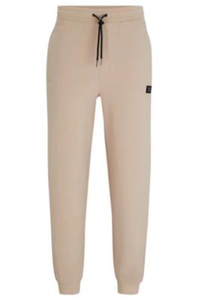 Hugo Stretch-cotton Tracksuit Bottoms With Stacked Logo In Beige