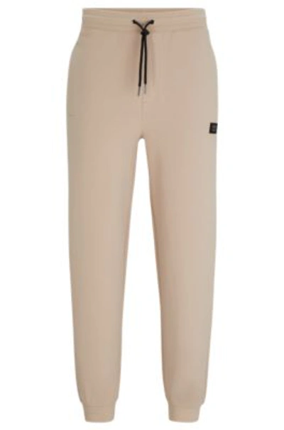 Hugo Boss Stretch-cotton Tracksuit Bottoms With Stacked Logo In Beige
