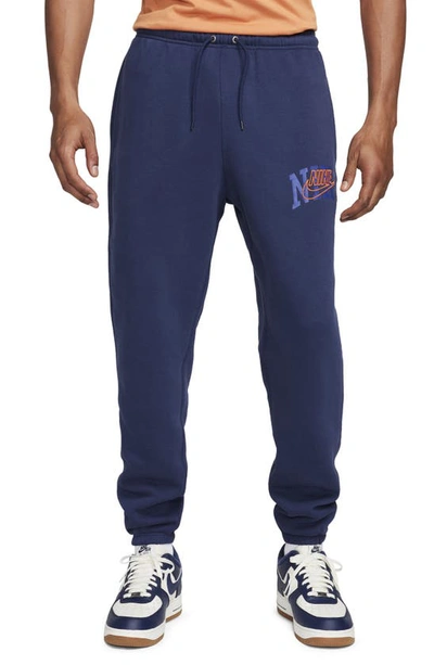 Nike Men's Club Fleece Cuffed Pants In Midnight Navy/safety Orange