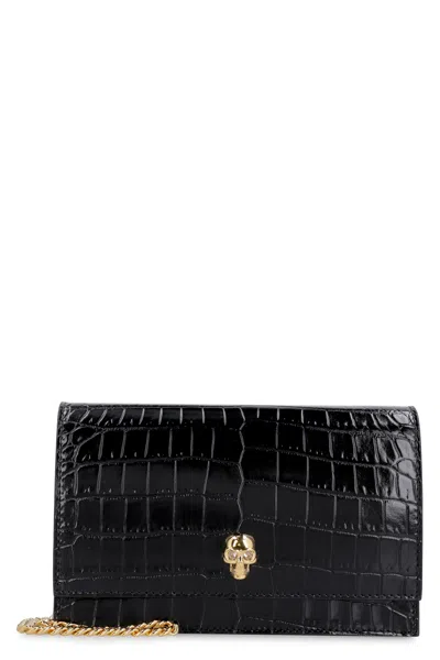 Alexander Mcqueen Elegant Crocodile Print Leather Clutch With Embellished Metal Skull And Chain Strap In Black