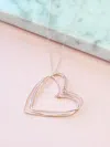 A Blonde And Her Bag Rose Gold Hearts Necklace On A Silver Chain In Blue