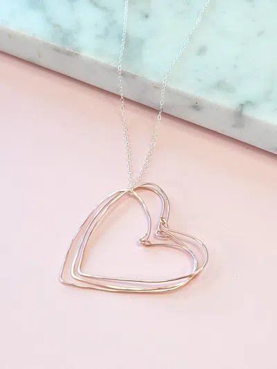 A Blonde And Her Bag Rose Gold Hearts Necklace On A Silver Chain In Blue