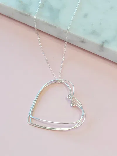 A Blonde And Her Bag Silver Hearts Necklace On A Silver Chain In Blue