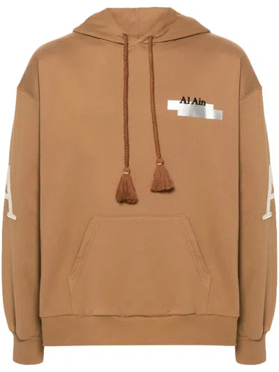 Al Ain Graphic-print Cotton Hoodie In Brown
