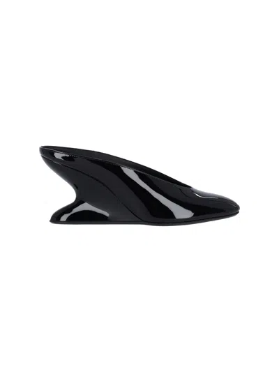 ALAÏA MULES WITH CURVED WEDGES