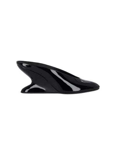 ALAÏA MULES WITH CURVED WEDGES