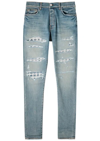 Amiri Quad Repaired Distressed Skinny Jeans In Indigo