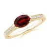 Angara East-west Oval Garnet Solitaire Ring With Diamonds In Yellow Gold/rich Red