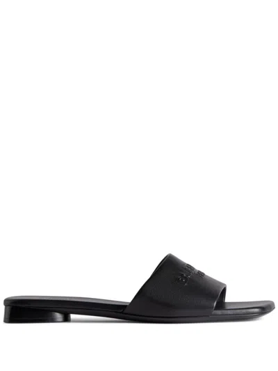 BALENCIAGA BLACK LEATHER FLAT SANDALS FOR WOMEN WITH EMBOSSED LOGO AND SLIP-ON STYLE