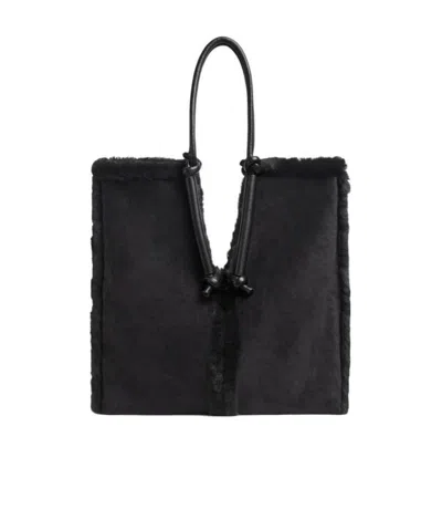 Bottega Veneta Bolster Reversible Shearling Suede Bag In Black