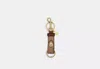 Coach Outlet Trigger Snap Bag Charm In Signature Canvas In Brown