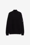 C.p. Company Ribbed Knit Roll Neck Sweater With Signature Lens Detail And Zip Pocket In Black