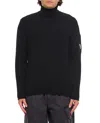C.p. Company Ribbed Knit Roll Neck Sweater With Signature Lens Detail And Zip Pocket In Black
