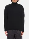 C.p. Company Ribbed Knit Roll Neck Sweater With Signature Lens Detail And Zip Pocket In Schwarz