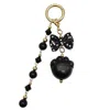Farra Women's Black Obsidian Cat Paw With Bowknot And Tassel Bag Charm In Black