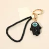 Fashnzfab Bling Studded Evil Eye Hamsa Hand Charm Keychain Bag Charm Phone Holder In Black