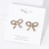 Fashnzfab Crystal Stone Studded Ribbon Stud Earrings In Gold
