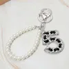 Fashnzfab Faux Leather Threaded Number Five Pearl Beaded Keychain / Bag Charm In Brown