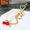 Fashnzfab Metal Heart Bow Pearl Beaded Cherry Charm Drop Keychain / Bag Charm In Gold