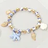 Fashnzfab Metal Pearl Sea Shell Ceramic Starfish Charm Floral Ball Beaded Stretch Bracelet - Blue, Gold In Gold