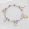 Fashnzfab Metal Shell Puka Shell Starfish Charm Station Ceramic Ball Beaded Stretch Bracelet In Gold
