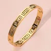 Fashnzfab Stainless Steel Greek Key Pattern Cutout Hinged Bangle Bracelet In Gold