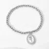 Fashnzfab Stainless Steel Stone Paved Tulip Flower Embossed Mother Of Pearl Oval Charm Beaded Stretch Bracelet In Multi