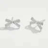 Fashnzfab White Gold Dipped Cz Stone Paved Mini Bow Stud Earrings - Silver In Metallic