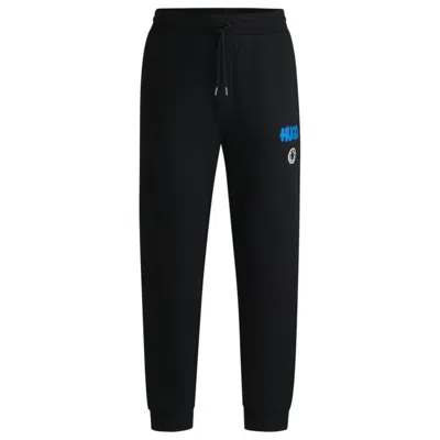 Hugo Boss Cotton-terry Tracksuit Bottoms With Happy Hugo Logo In Black