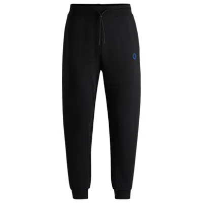 Hugo Boss Cotton-terry Tracksuit Bottoms With Happy Hugo Logo Patch In Black