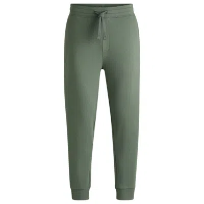 Hugo Boss Cotton-terry Tracksuit Bottoms With Logo Print In Green