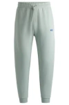 Hugo Boss Cotton-terry Tracksuit Bottoms With Blue Logo Patch In Light Green