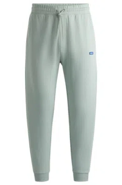 Hugo Boss Cotton-terry Tracksuit Bottoms With Blue Logo Patch In Light Green