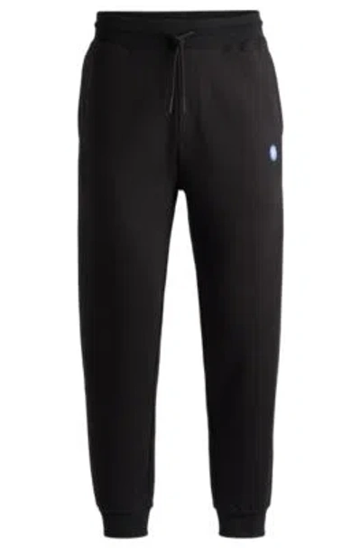 Hugo Cotton-terry Tracksuit Bottoms With Smiley-face Logo Patch In Black