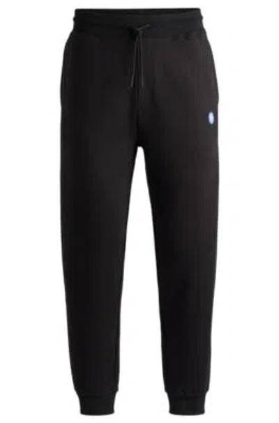 Hugo Boss Cotton-terry Tracksuit Bottoms With Smiley-face Logo Patch In Black