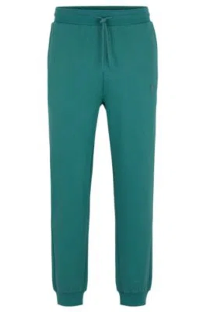Hugo Boss Cotton-terry Tracksuit Bottoms With Smiley-face Logo Patch In Green