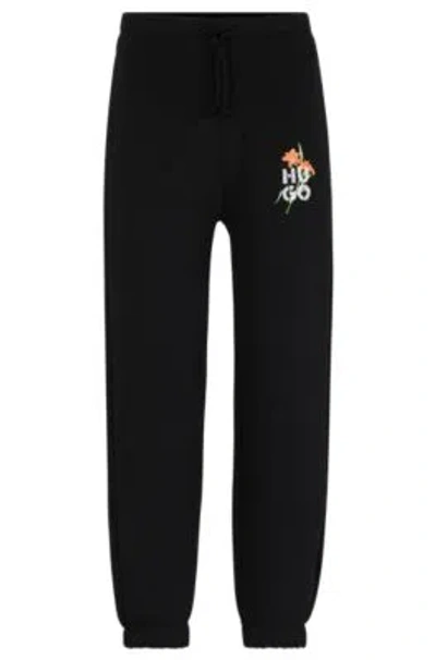 Hugo Boss Relaxed-fit Tracksuit Bottoms With Floral Logo Artwork In Black