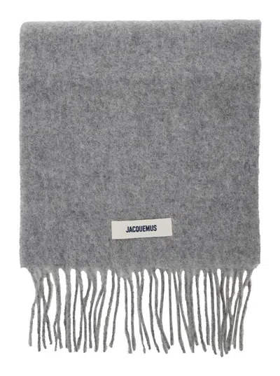 JACQUEMUS 'L'ECHARPE CARRO' GREY SCARF WITH LOGO PATCH ON THE FRONT AND FRINGED HEM IN WOOL BLEND MAN