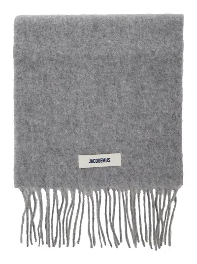 JACQUEMUS LECHARPE CARRO GREY SCARF WITH LOGO PATCH ON THE FRONT AND FRINGED HEM IN WOOL BLEND MAN