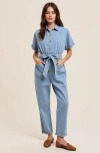 Modenaire Denim Jumpsuit With Tie Waist Rolled Cuffs And Button Front In Blue