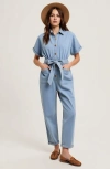 Modenaire Short Sleeve Button Front Tie Waist Rolled Cuff Denim Jumpsuit In Blue